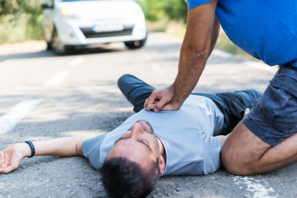 Bystander performing chest compressions on an unconscious man
