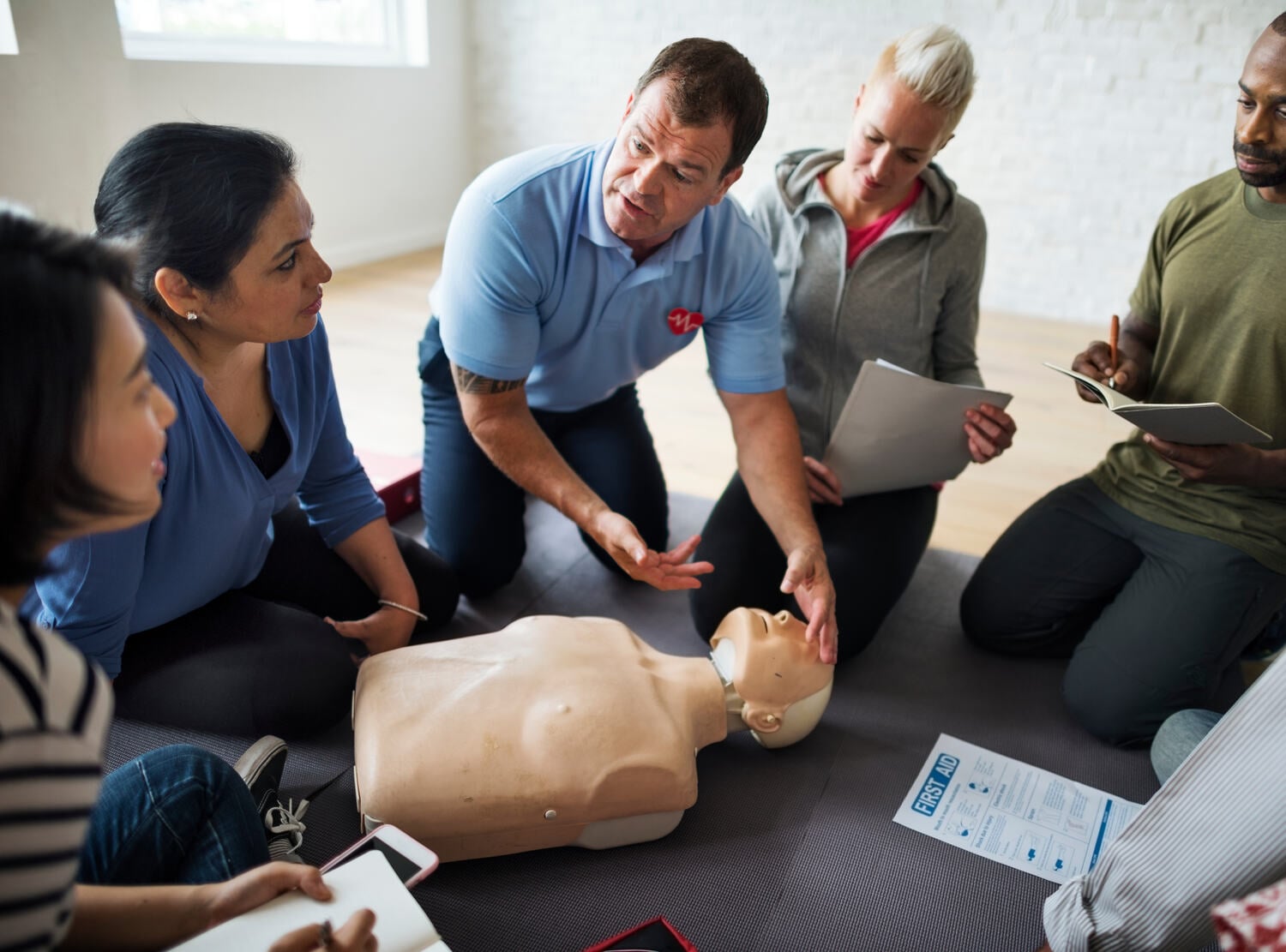 Instructor demonstrating CPR to a small group
