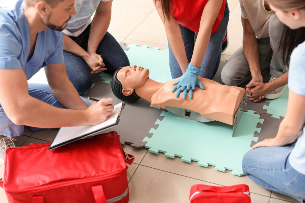 Group of people practising CPR on a training manikin