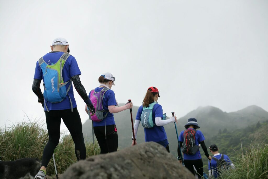 Group of hikers trekking mountain trail in foggy conditions