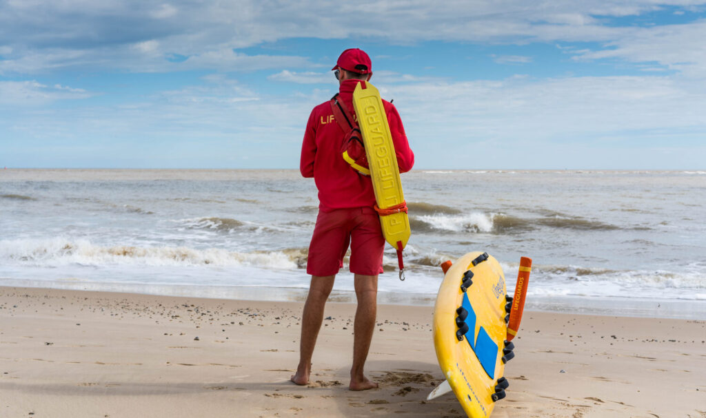 Lifeguard on beach patrol with rescue equipment