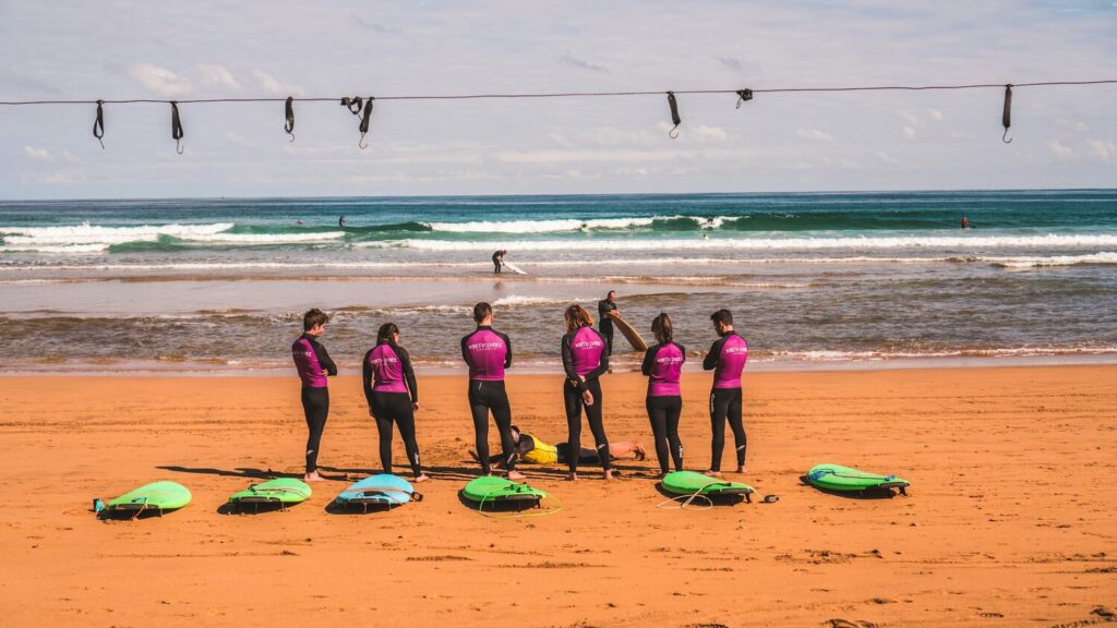 Surf school group receiving beach instruction before entering water