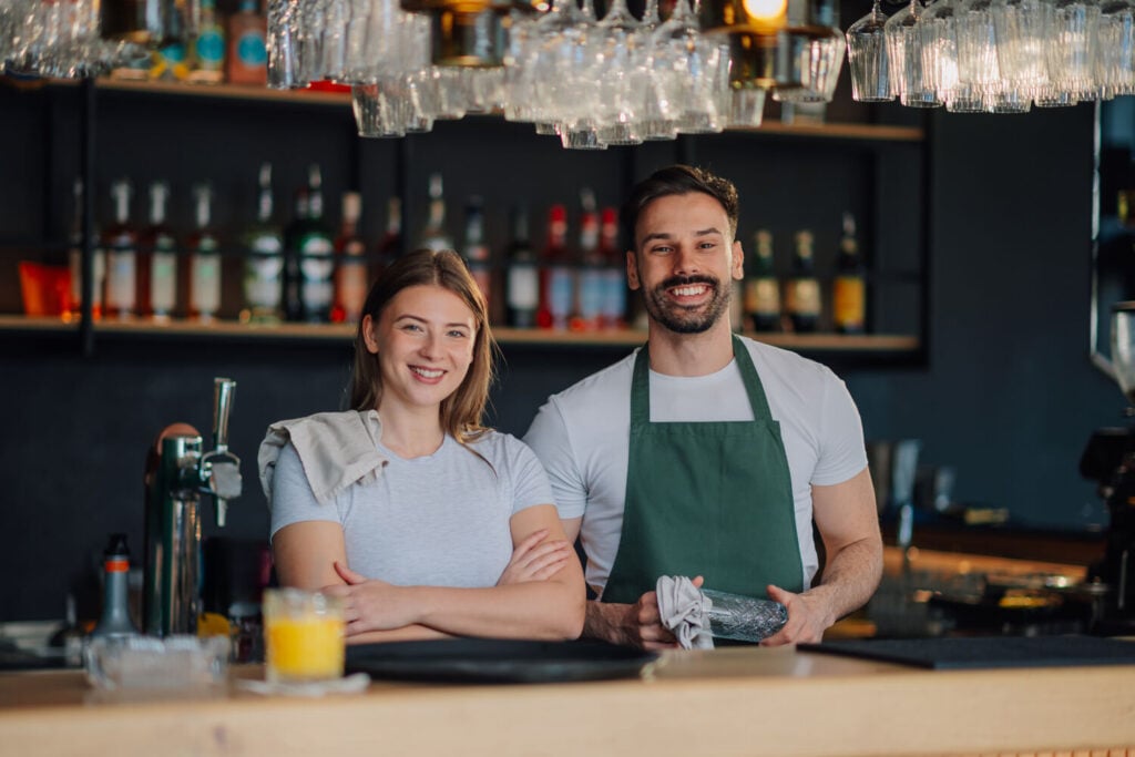 Two-bar-staff-smiling-behind-the-counter