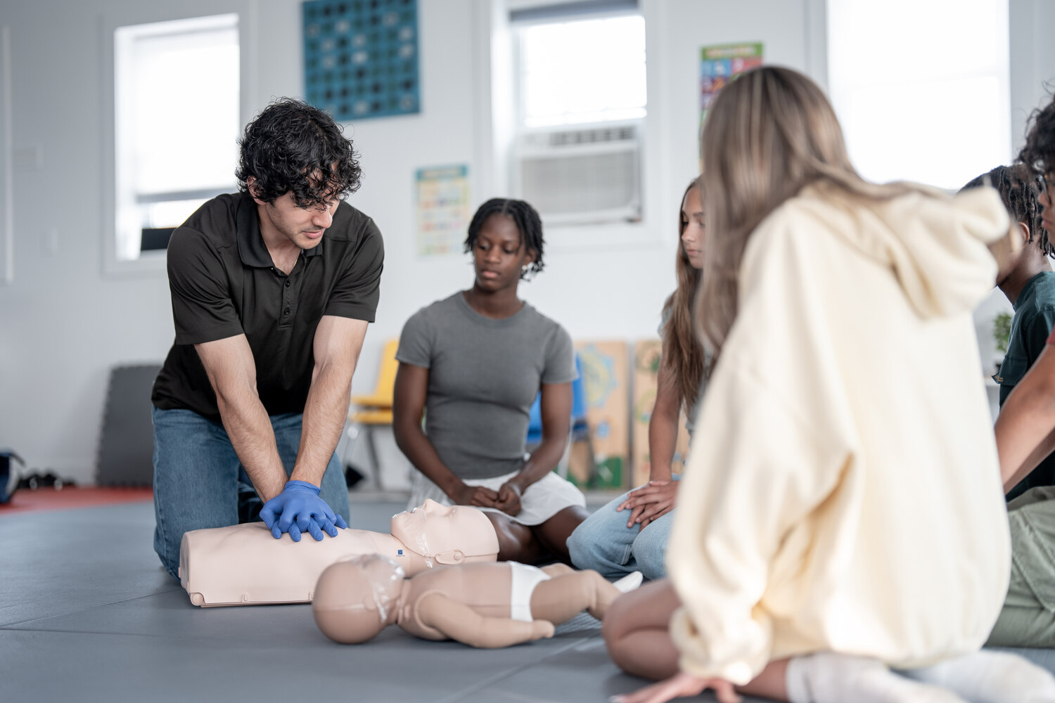 Instructor demonstrating CPR to a group of students